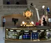 The image depicts the iconic gold-toned clock above the Information Booth in Grand Central Terminal with an American flag hanging in the background