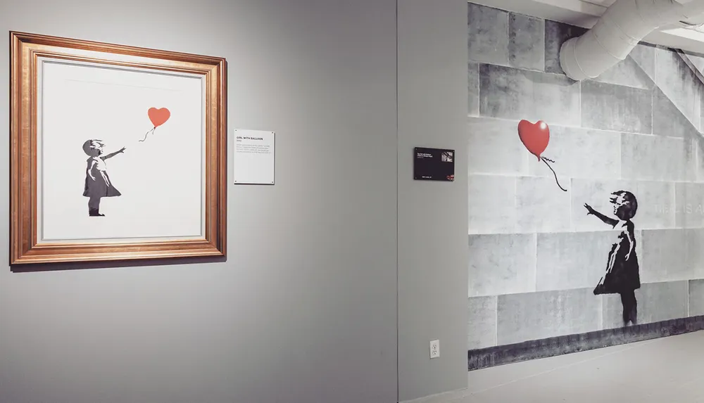 The image features an interior wall of a gallery with opposite displays of an artwork depicting a girl reaching for a heart-shaped balloon one is a framed print and the other is a larger mural-style representation