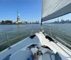 This is a daytime photo featuring the Statue of Liberty viewed from a boat with clear skies and a section of the boats rigging visible in the frame