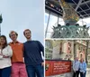 A group of five individuals is posing for a photo with the Statue of Liberty towering in the background