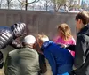 A group of five individuals is posing for a photo with the Statue of Liberty towering in the background