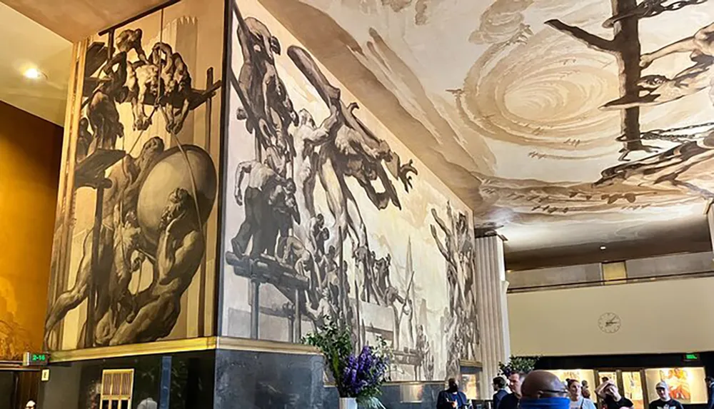 The image shows an interior space with people where large monochromatic murals are displayed on the walls and the ceiling is adorned with a circular painting pattern evoking a classical or period atmosphere