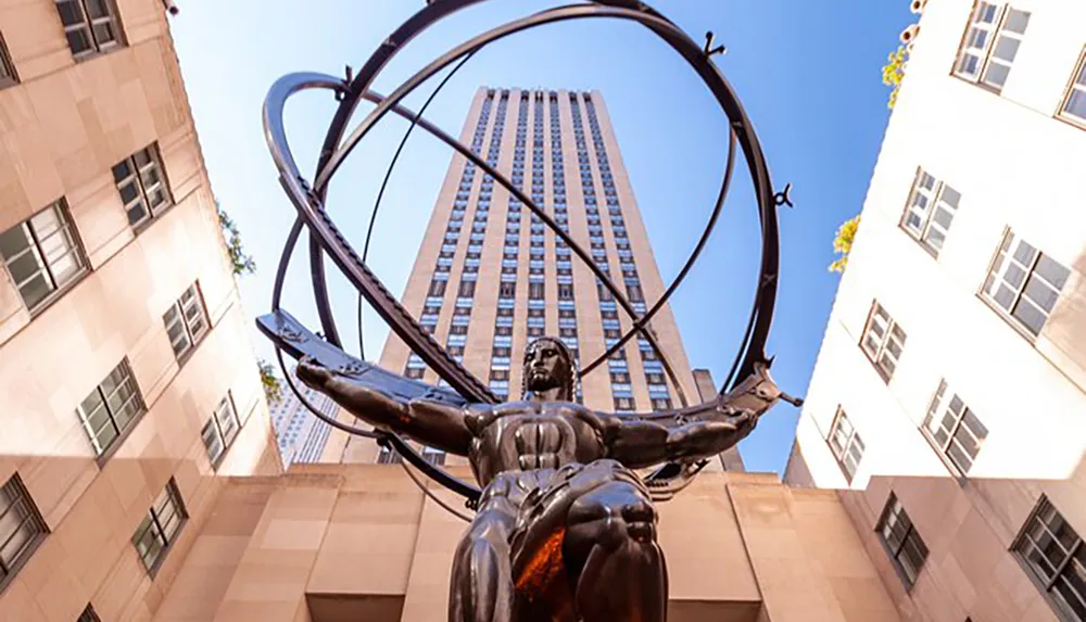 The image shows the Atlas statue in front of the Rockefeller Center in New York City with the art-deco style skyscraper towering in the background