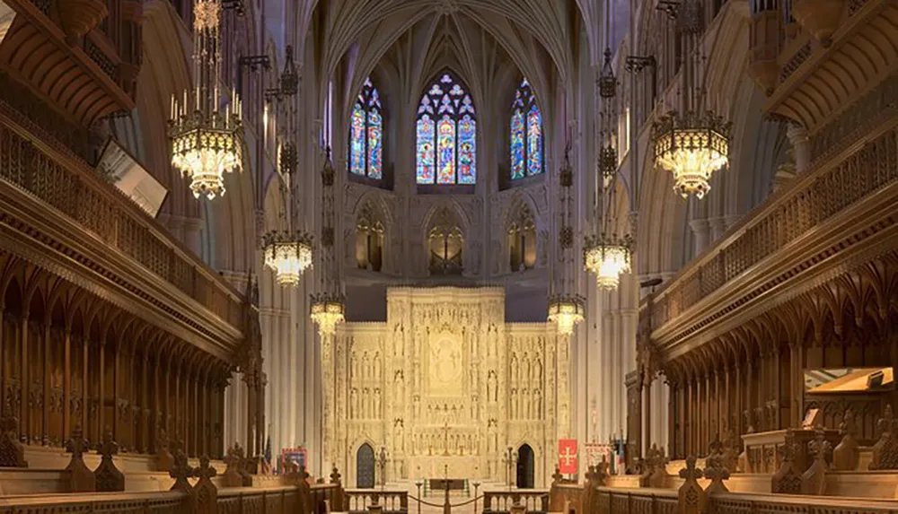 The image shows the ornate gothic interior of a cathedral with stained glass windows chandeliers and an elaborately carved altar