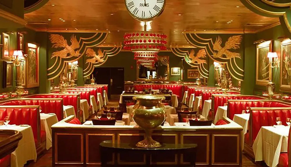 This image shows an opulent restaurant interior with rich red upholstered seating dark green walls with golden phoenix motifs white-clothed tables and an ornate large clock hanging on the wall