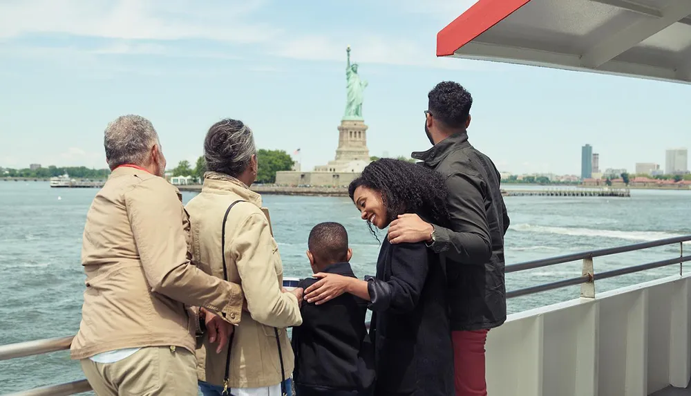 A group of people are enjoying the view of the Statue of Liberty from a boat