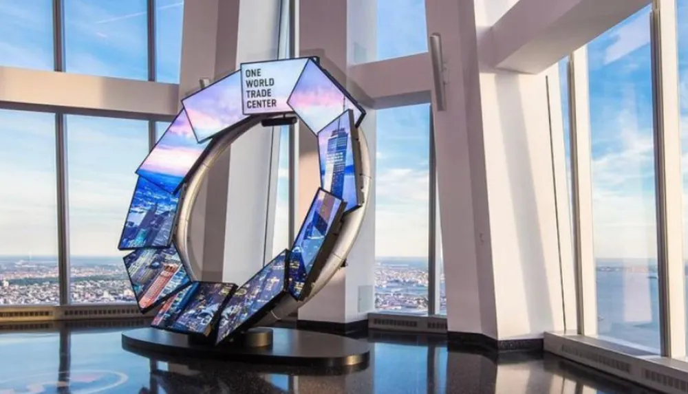 An interactive display in the shape of an O stands inside the observatory of One World Trade Center offering a view of the cityscape through large windows