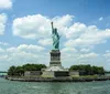 Tourists on a boat are viewing and taking photos of the Statue of Liberty