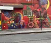 A person is smiling and pointing towards a vibrant street mural that promotes safety and community in an urban setting