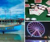 A colorful boat labeled Atlantic City sits on the shore with a large Ferris wheel and an amusement park on a pier in the background