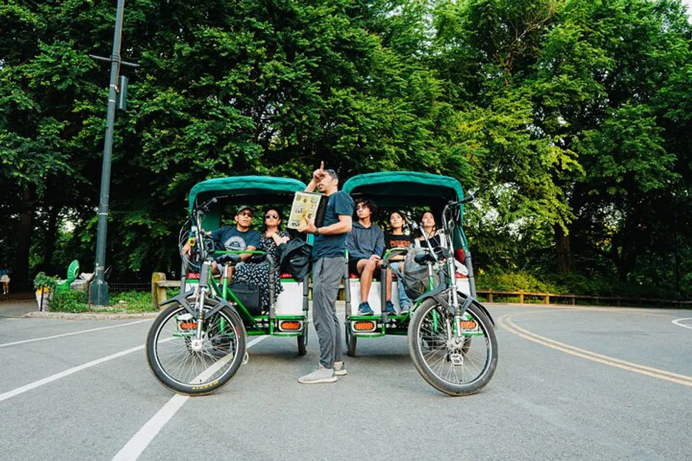A group of people are enjoying a ride in pedal-powered rickshaws with one person standing and reading a map