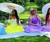 A family of four is smiling and enjoying an outdoor meal together