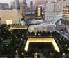The image shows a high-angle view of the 911 Memorial in New York City at dusk with the illuminated twin reflecting pools surrounded by trees and bordered by modern buildings