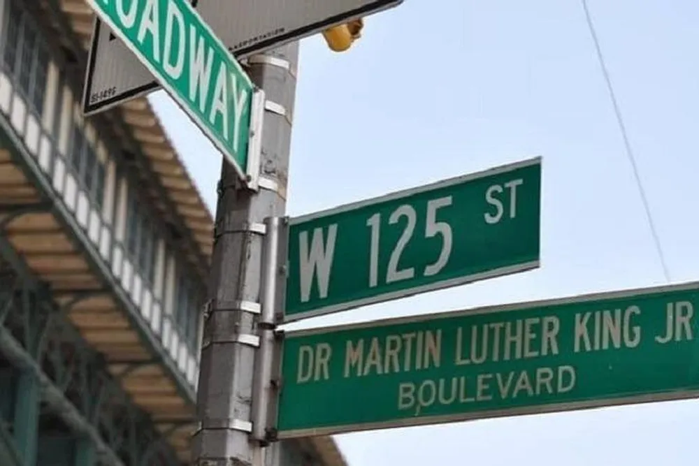 The image shows street signs at an intersection with Broadway and W 125 St signs crossed and a sign for Dr Martin Luther King Jr Boulevard below them likely located in New York City