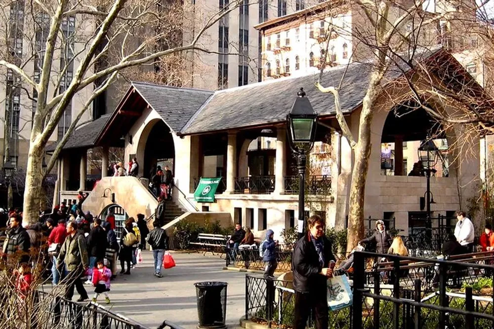 The image depicts a bustling urban park setting with people walking and sitting near a charming building bare trees and a lamppost suggesting a lively community space in a city environment