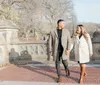 A couple shares an affectionate moment under an ornate arched passageway with a staircase in the background