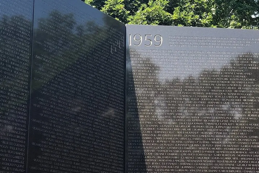 This image shows a black memorial wall with numerous names inscribed on it and the year 1959 prominently displayed suggesting it is a tribute to individuals from that year