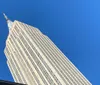 The image shows the towering facade of a skyscraper against a clear blue sky