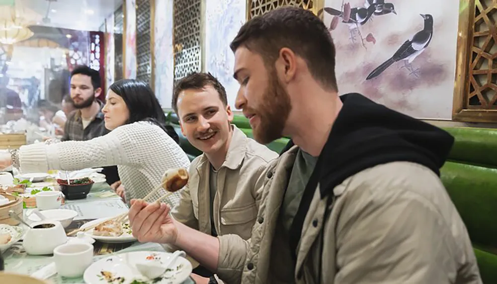 A group of people are enjoying a meal together at a restaurant with Chinese-style decor