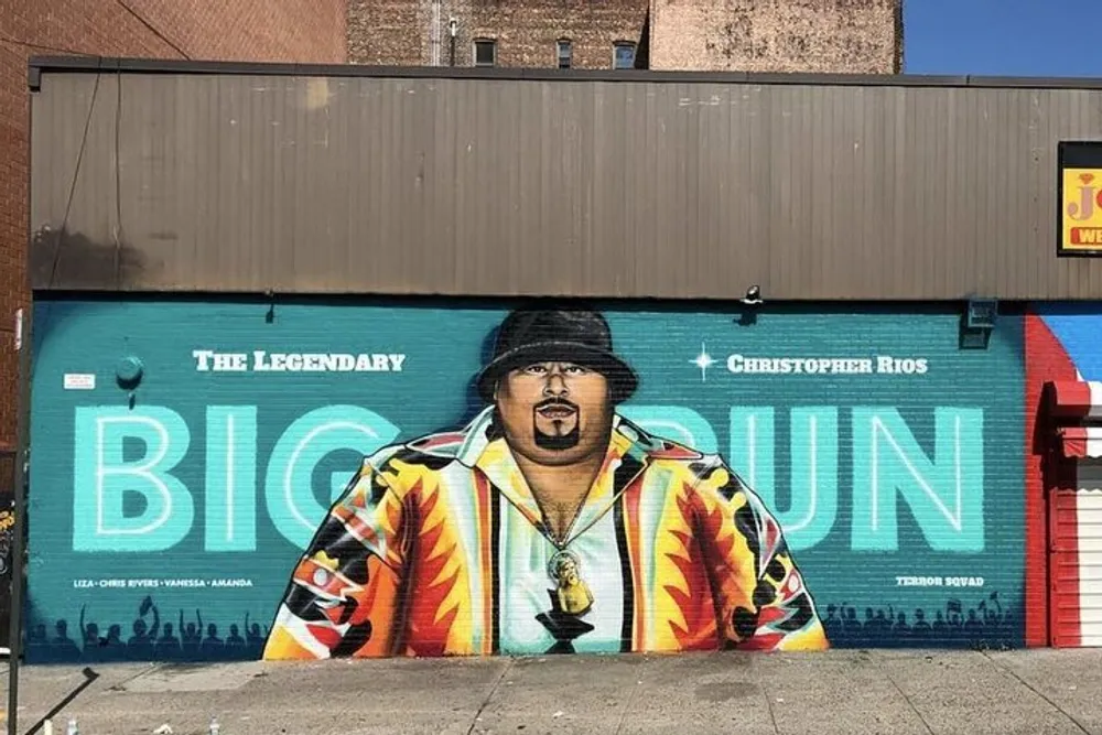 A vibrant mural honors a legendary music artist with colorful attire and a prominent name displayed on a buildings wall