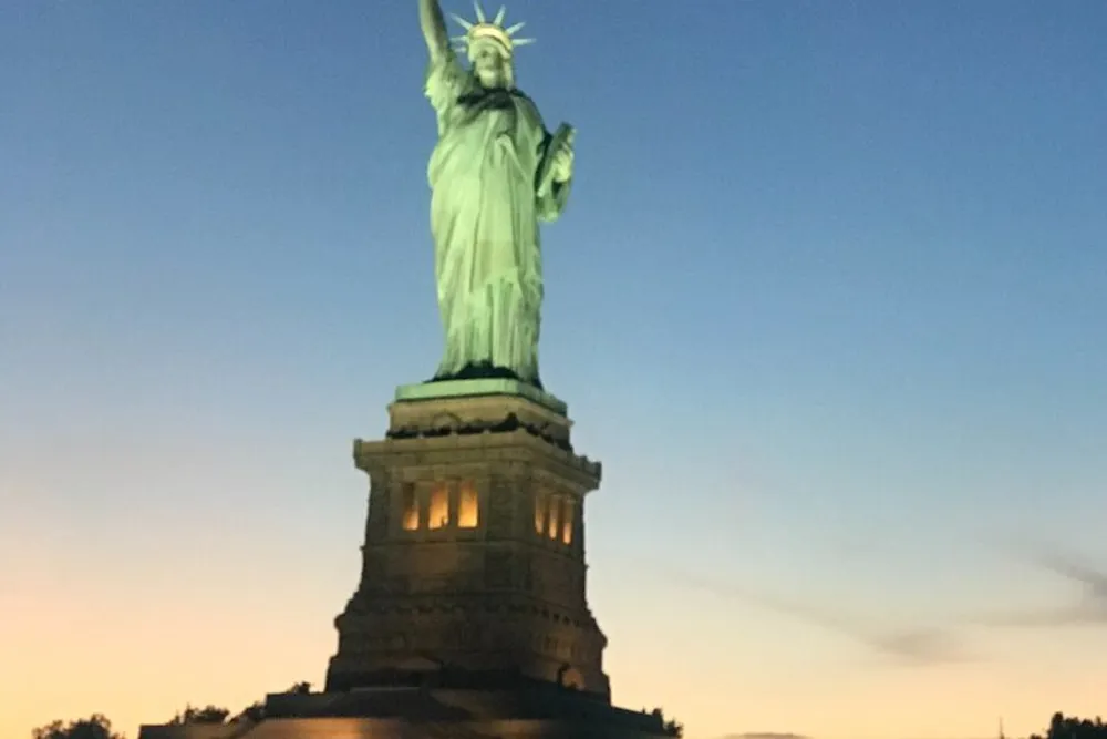 The image shows the Statue of Liberty against a twilight sky