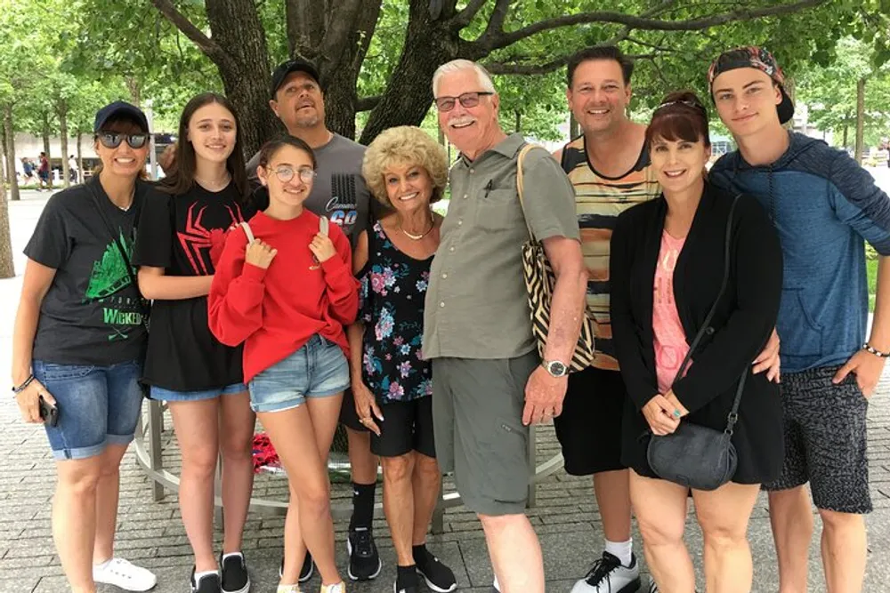 A group of eight people spanning multiple generations is posing happily for a photo together outdoors