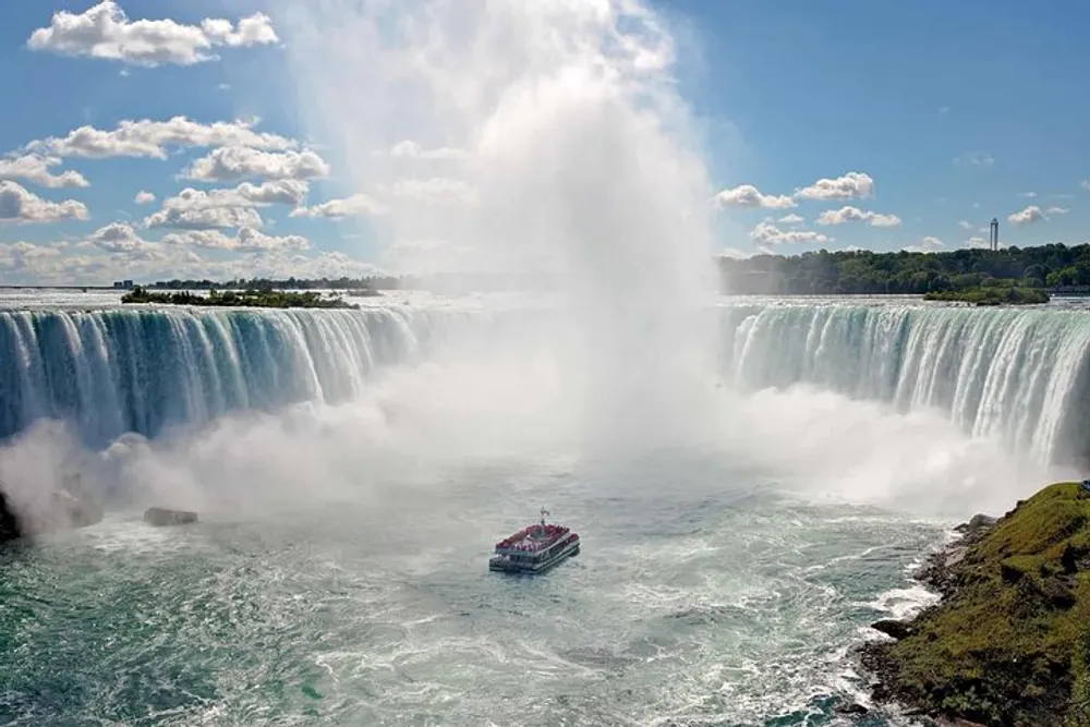 A tour boat approaches the mist of Niagara Falls on a sunny day