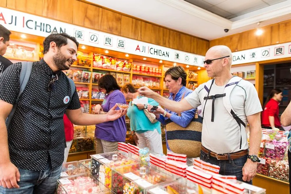 A group of people are interacting and trying out products at a colorful candy store