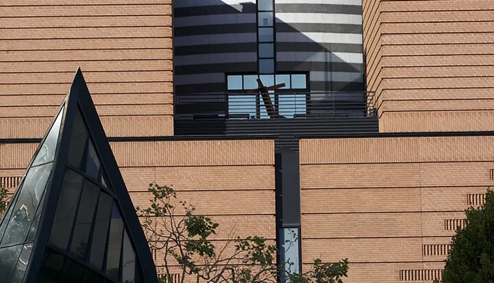 A person stands between two buildings appearing to push them apart due to the perspective