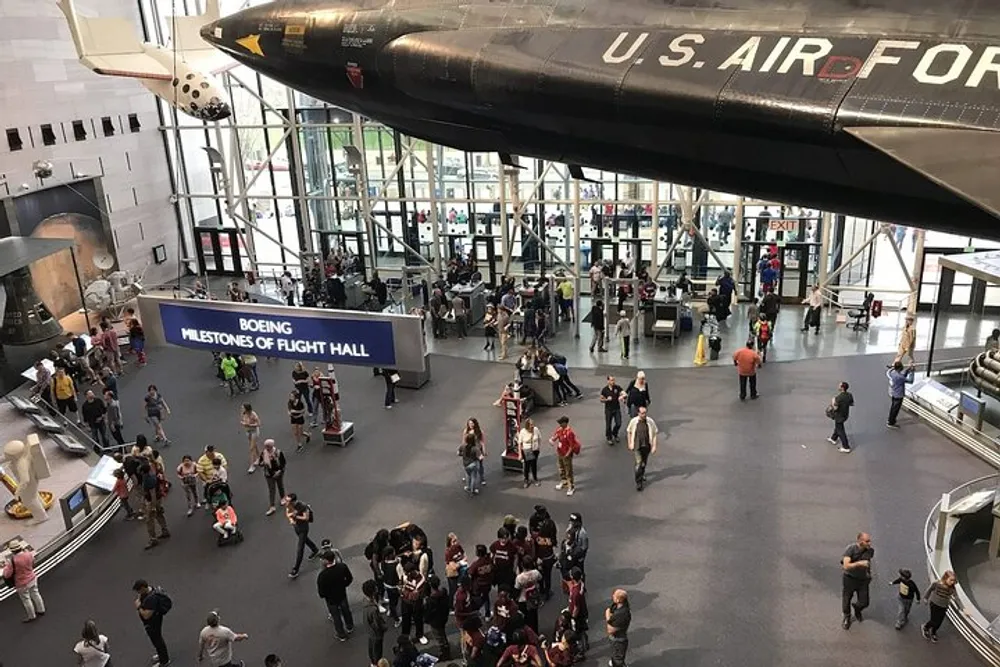 Visitors explore exhibits beneath an impressive aircraft display at the Boeing Milestones of Flight Hall