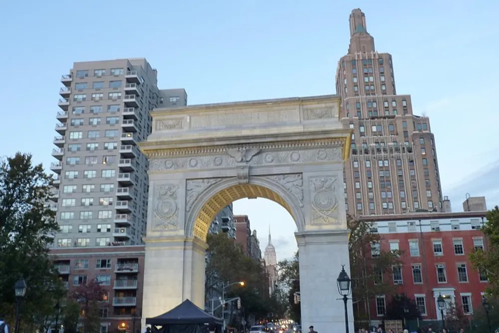 The image shows the Washington Square Arch with surrounding buildings in the background during twilight