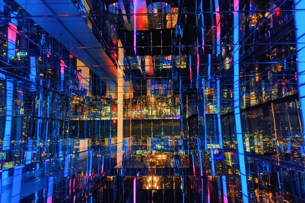 The image shows a vibrant and colorful interior covered in mirrors creating a kaleidoscopic effect with reflections of city lights
