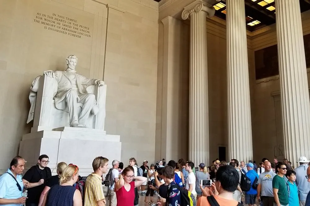 Visitors gather around the large seated statue inside the Lincoln Memorial in Washington DC