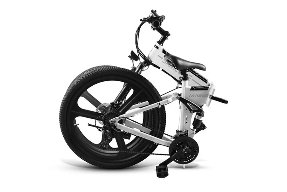 The image features a modern folded white and black electric bicycle against a white background