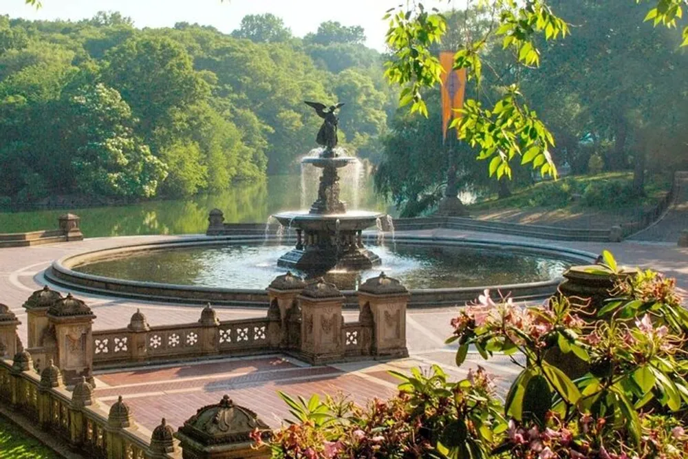 The image shows an ornate fountain surrounded by lush greenery and benches with the early morning sunlight casting a warm glow over the serene setting