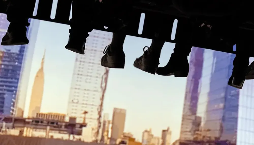 The image shows an upside-down view of city buildings with a row of hanging shoes in silhouette against the sky