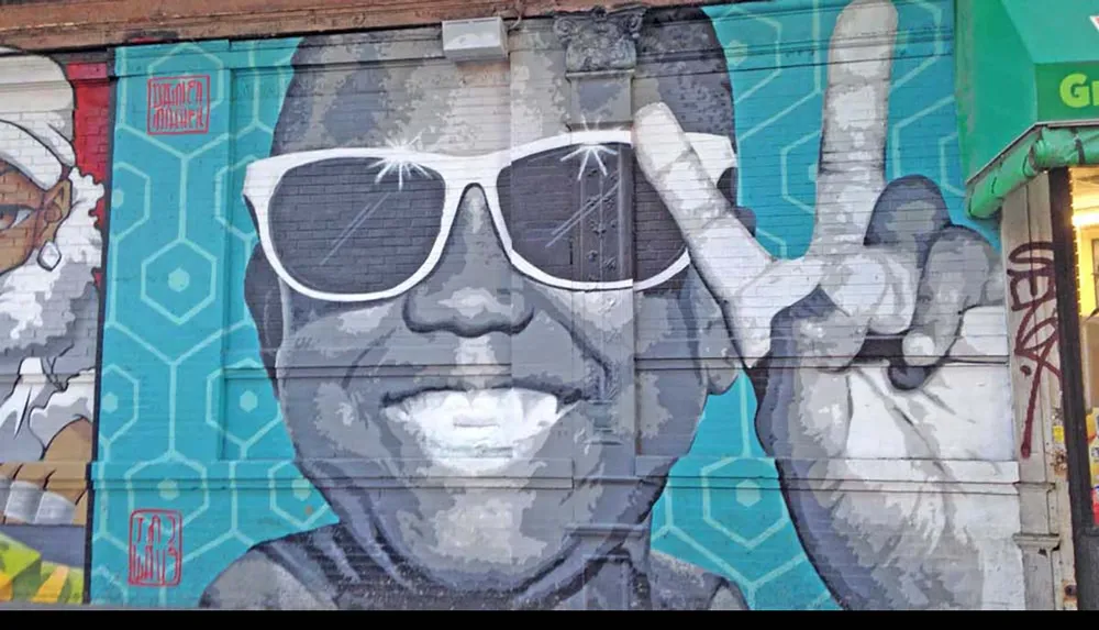 The image features a colorful urban mural of a person wearing sunglasses making a peace sign with their hand
