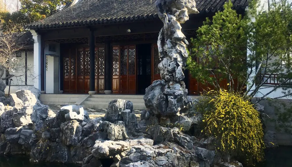 The image showcases a traditional Chinese garden complete with ornate rock formations a classical pavilion and lush plant life