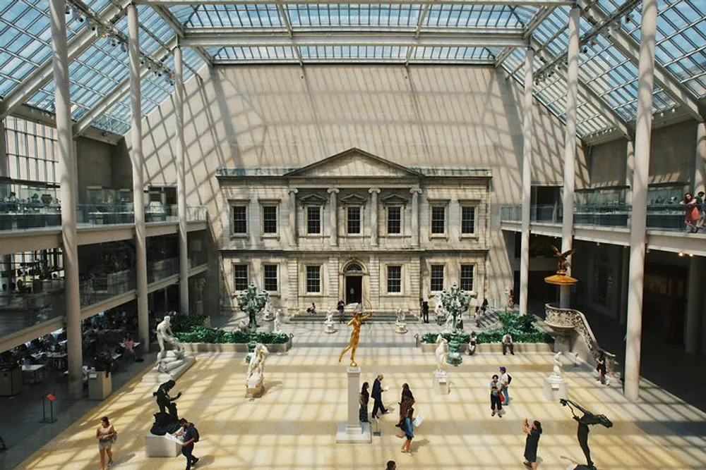 The image shows a spacious sunlit atrium with classical architecture filled with sculptures and visitors resembling a gallery in an art museum