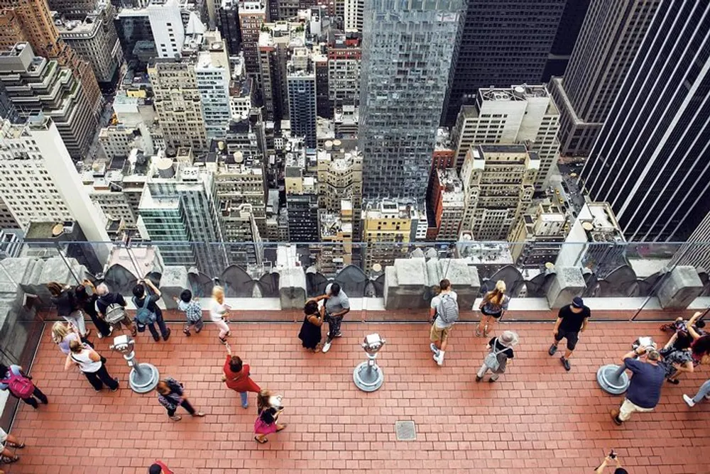 Visitors are enjoying an aerial view of a dense urban skyline from a high observation deck