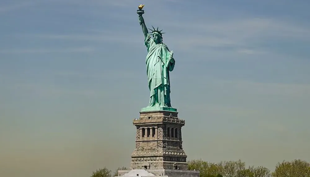 The image shows the Statue of Liberty against a clear blue sky a symbol of freedom and democracy