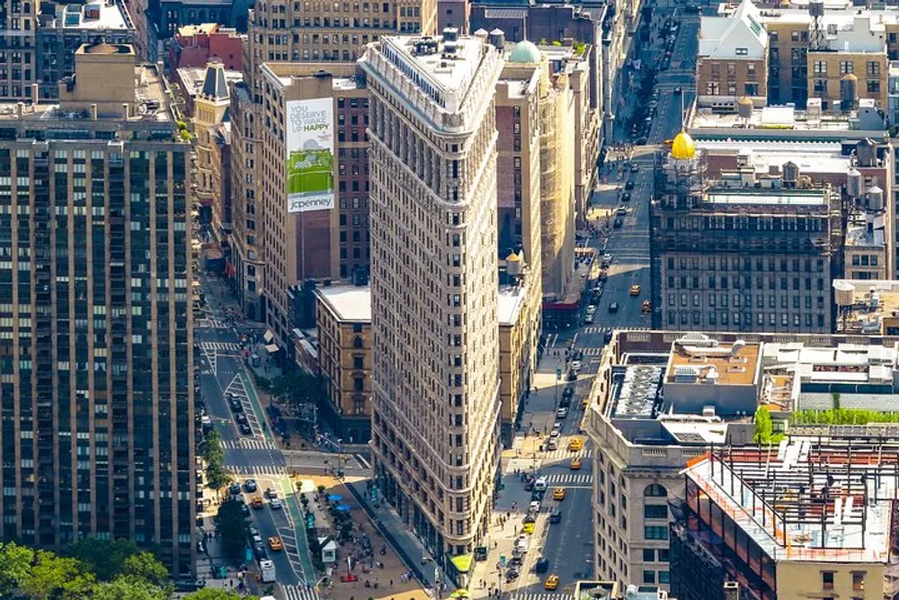 This is an aerial view of the Flatiron Building a distinctive triangular skyscraper located in Manhattan New York City surrounded by other buildings and busy streets