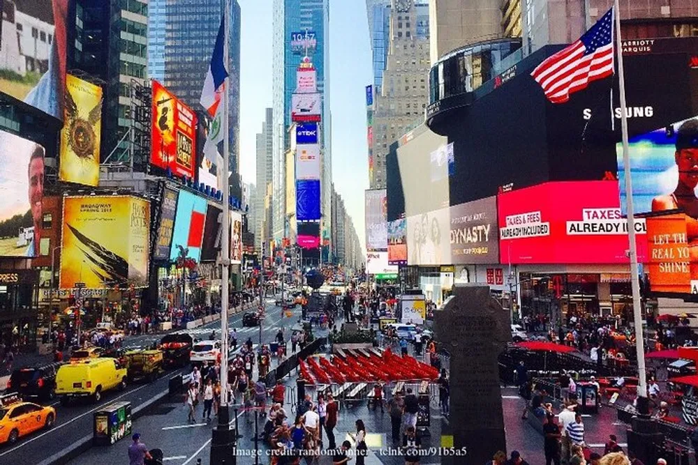 The image captures the bustling atmosphere of Times Square in New York with bright billboards heavy traffic and clusters of pedestrians