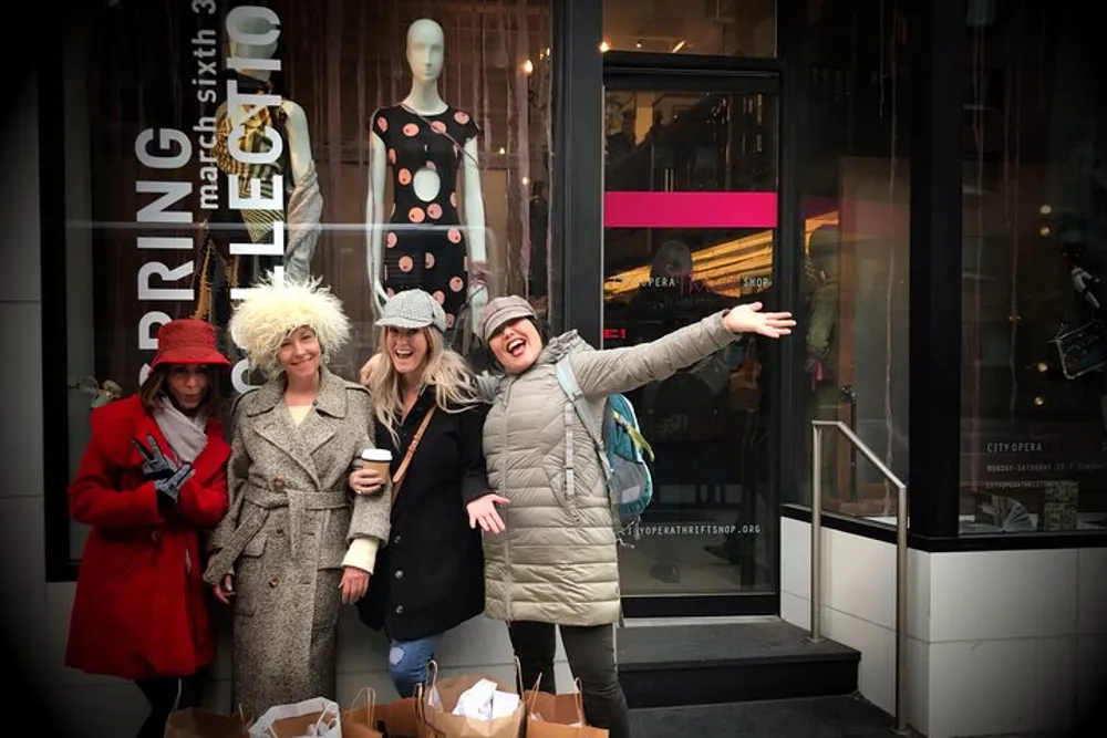 A group of cheerful people pose for a photo on a city sidewalk with one mimicking the mannequins pose in the background