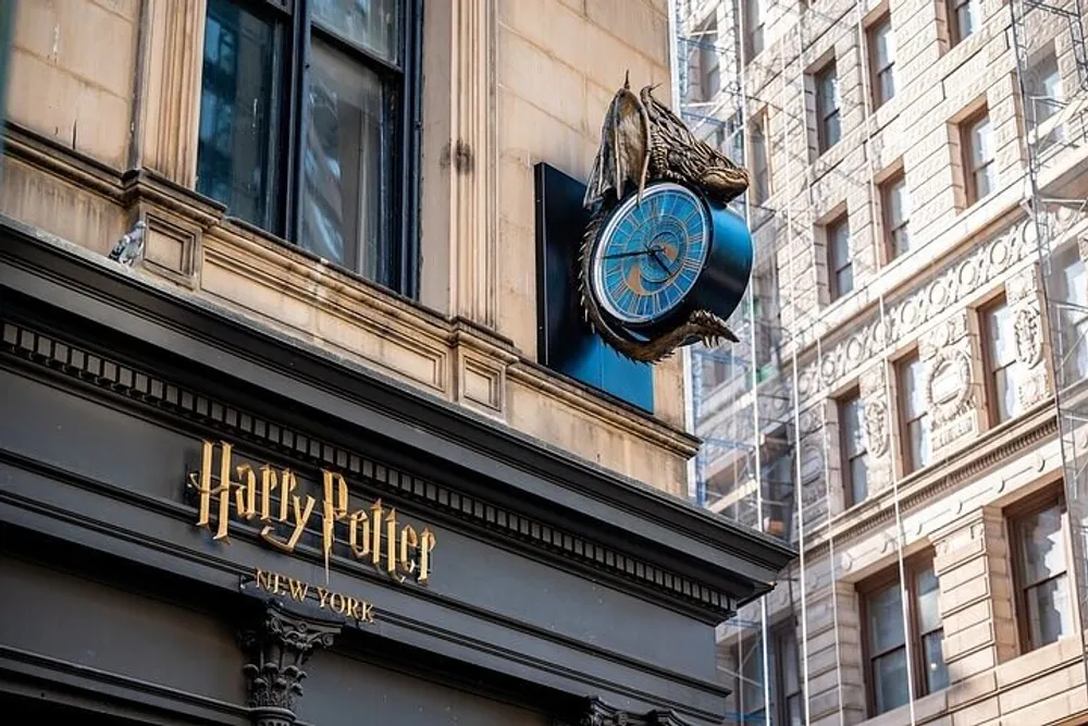 The image shows the exterior of a building with a sign reading Harry Potter New York and a large ornamental clock with wings resembling the Time-Turner from the Harry Potter series