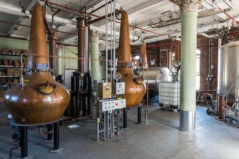 The image shows a distillery with copper pot stills and various industrial equipment used for the production of spirits