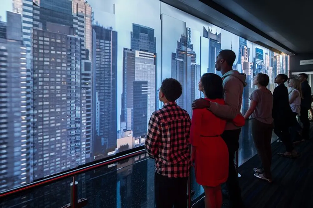 A group of people is looking out of a high vantage point at a cityscape through large windows