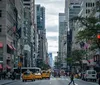 The image depicts a bustling New York City street with pedestrians yellow taxis and American flags fluttering on buildings encapsulating the vibrant urban life of the city