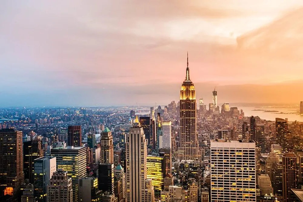 This image captures a breathtaking sunset view of the New York City skyline with the iconic Empire State Building prominently in the foreground