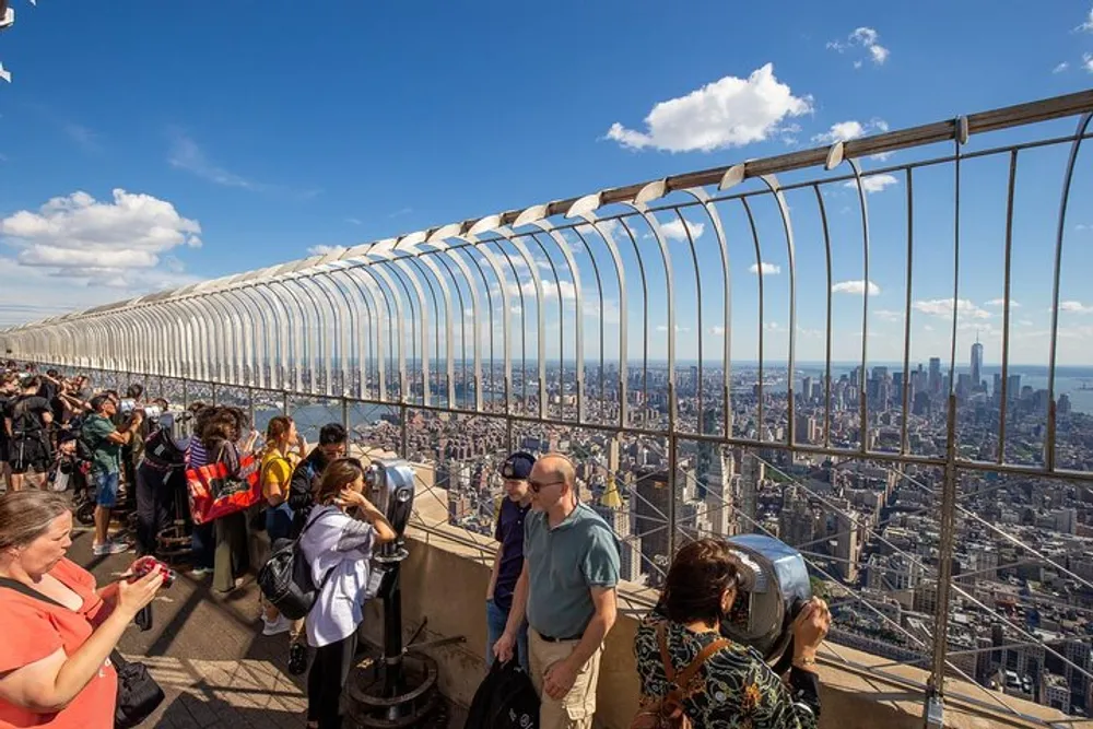 Tourists are enjoying a panoramic city view from a high vantage point behind a protective barrier